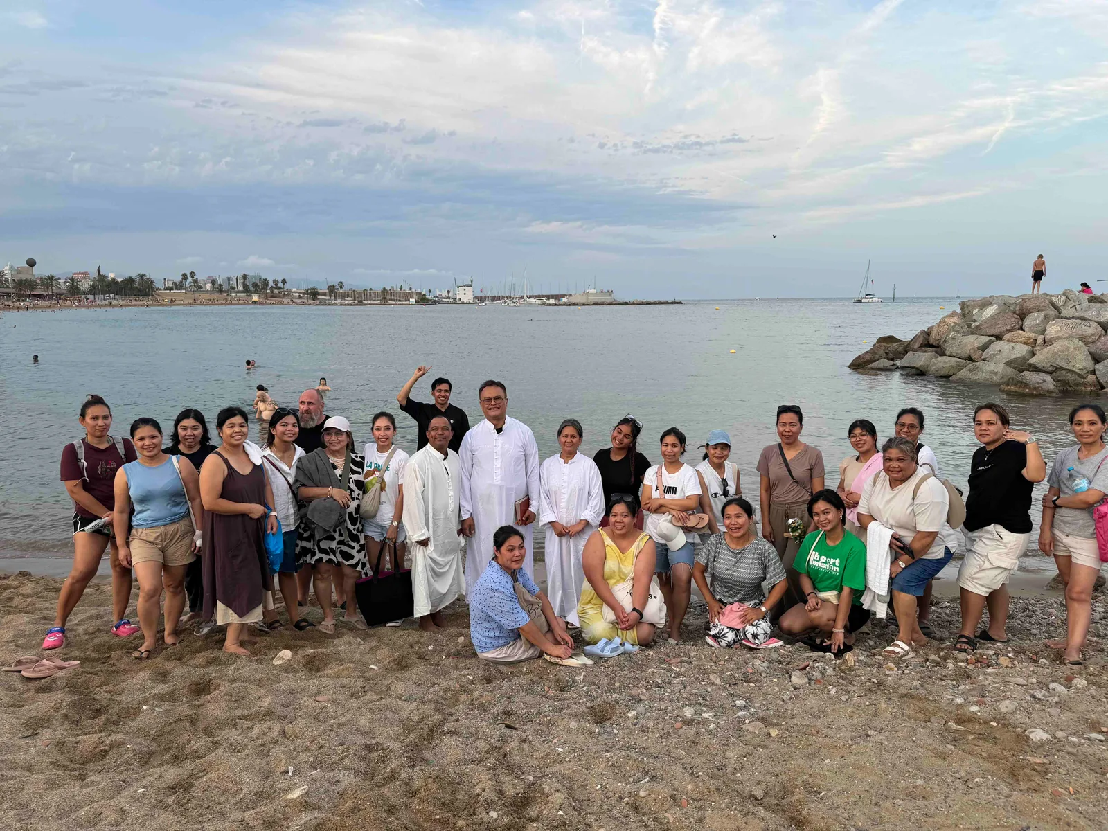 The church family gathered by the sea for a baptism