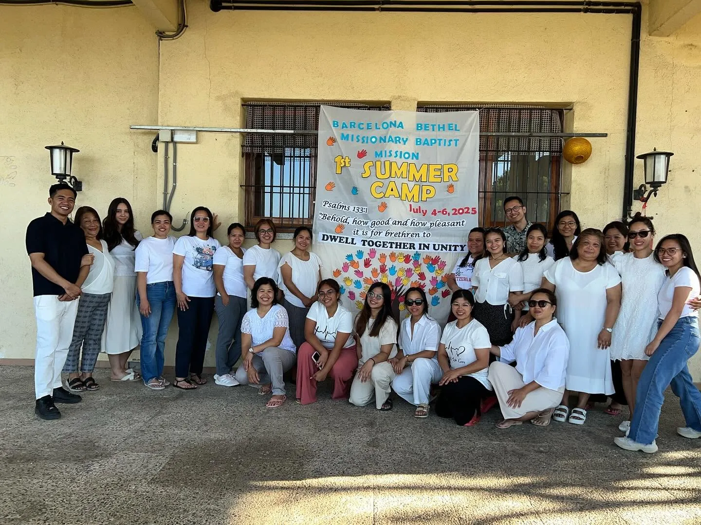 Barcelona summer church camp group gathered in front of the camp banner